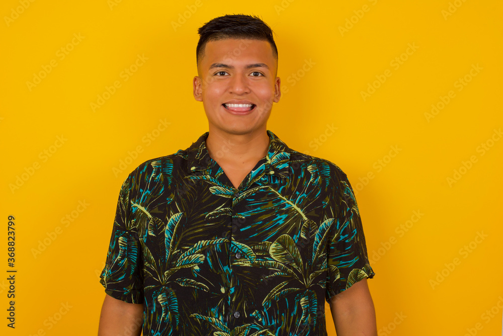 Beautiful Young caucasian man with happy and funny face smiling and showing tongue. Wearing casual clothes and standing against gray studio background. Beautiful Young caucasian man with happy and funny face smiling and showing tongue. Wearing casual clothes and standing against gray studio background.