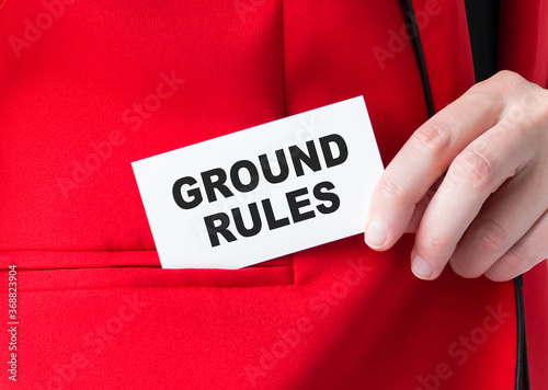 Businessman putting a card with text ground rules in the pocket