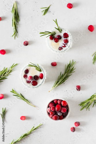 White cocktail with coconut milk, cranberry and rosemary alcoholic or moctail on white background