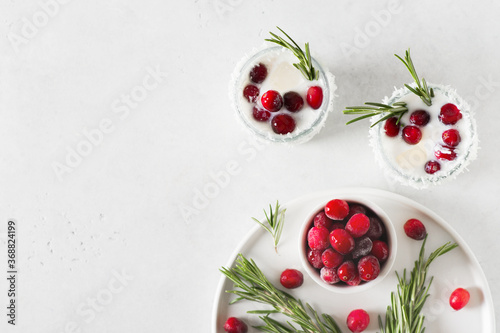 Fototapeta Naklejka Na Ścianę i Meble -  White cocktail with coconut milk, cranberry and rosemary alcoholic or moctail on white background