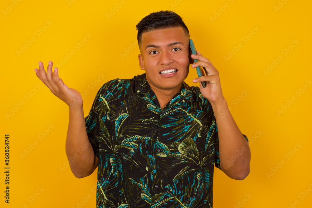 Young businessman talking on the phone over yellow background stressed with hand on face, shocked with shame and surprise face, angry and frustrated. Fear and upset for mistake. Young businessman talking on the phone over yellow background stressed with hand on face, shocked with shame and surprise face, angry and frustrated. Fear and upset for mistake.