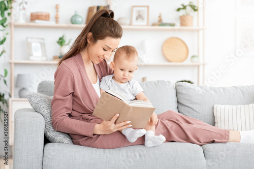 Loving Mom Reading Fairy Tales To Her Adorable Toddler Son At Home