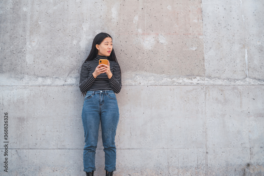 Asian woman using her mobile phone.