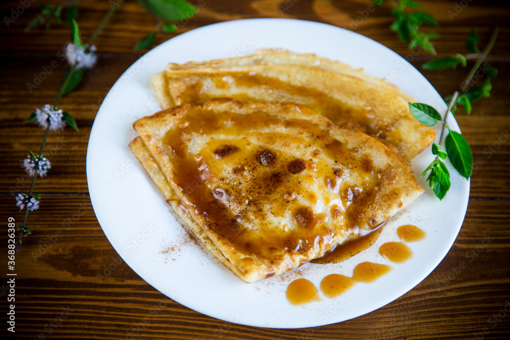 fried thin pancakes with sweet caramel in a plate