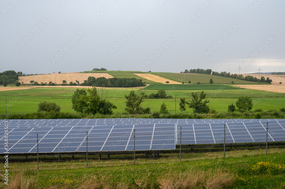 Beautiful sceenery of a little solar park in Bavaria, sourrounded by beautiful landscape in a little valley. Photograph was taken meanwhile sunset Beautiful sceenery of a little solar park in Bavaria, sourrounded by beautiful landscape in a little valley. Photograph was taken meanwhile sunset