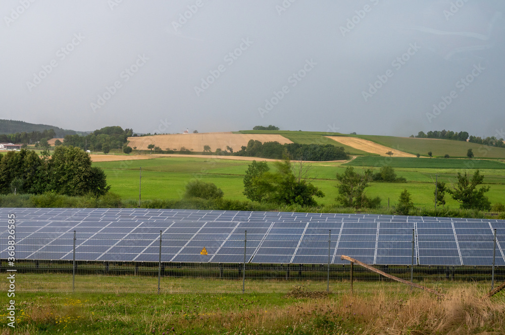 Beautiful sceenery of a little solar park in Bavaria, sourrounded by beautiful landscape in a little valley. Photograph was taken meanwhile sunset Beautiful sceenery of a little solar park in Bavaria, sourrounded by beautiful landscape in a little valley. Photograph was taken meanwhile sunset