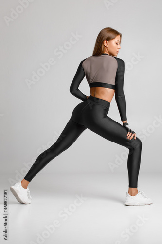 Sexy fitness woman. Beautiful athletic girl, isolated on the gray background