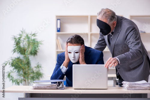 Old boss and young male employee wearing masks