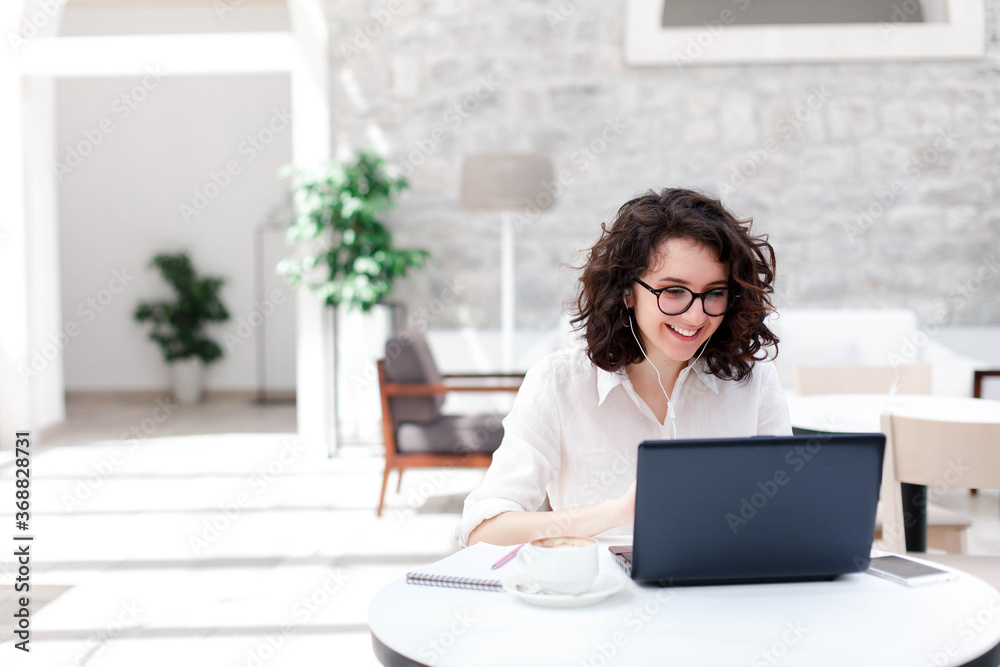 Young woman using laptop for webinar, video conference. Freelancer talking on virtual call and online meeting. Girl working in in coworking office. Connection, communication with social distance. Young woman using laptop for webinar, video conference. Freelancer talking on virtual call and online meeting. Girl working in in coworking office. Connection, communication with social distance.