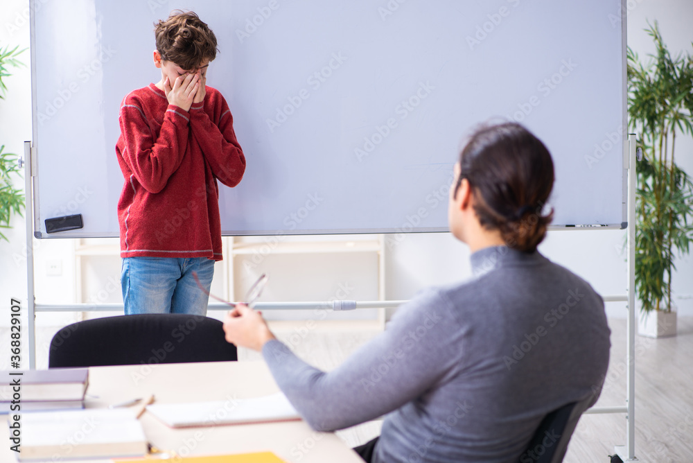 Young male teacher and schoolboy in the classroom Young male teacher and schoolboy in the classroom