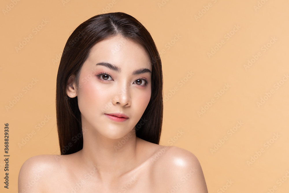Beautiful Asian woman looking at camera smile with clean and fresh skin Happiness and cheerful with positive emotional,isolated on Beige background,Beauty Cosmetics and spa Facial treatment Concept