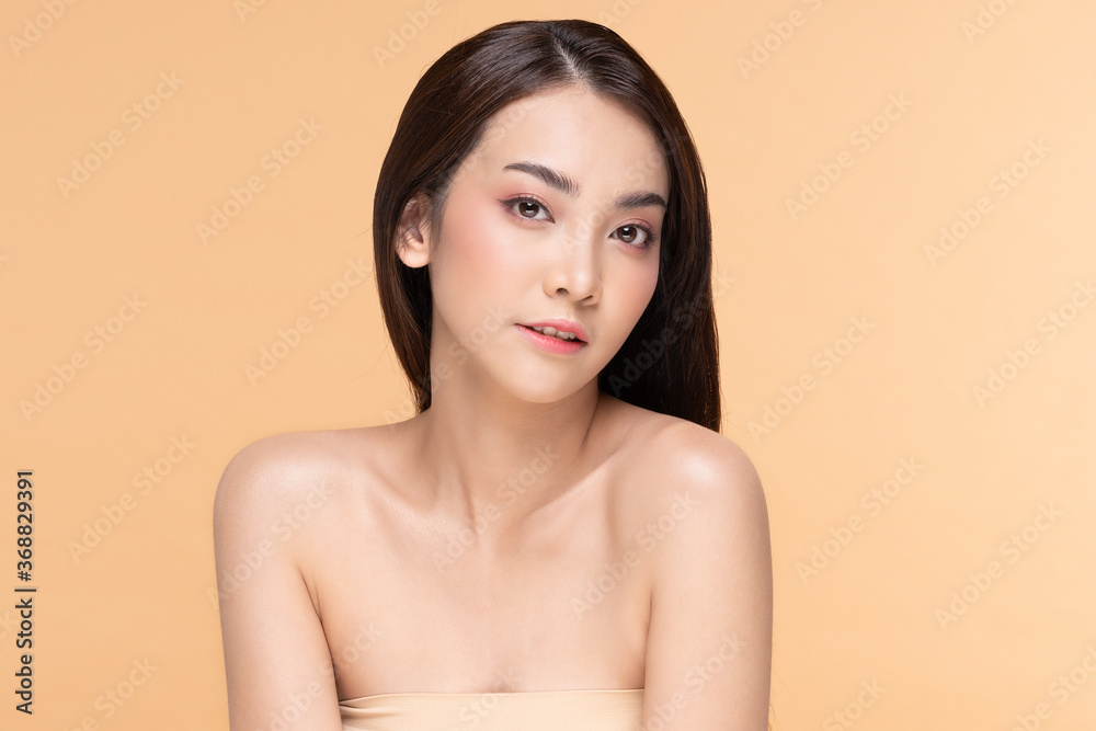 Beautiful Asian woman looking at camera smile with clean and fresh skin Happiness and cheerful with positive emotional,isolated on Beige background,Beauty Cosmetics and spa Facial treatment Concept