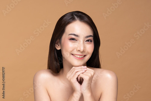 Young Beautiful Asian woman smile holding hands with clean and fresh skin Happiness and cheerful with positive emotional,isolated on Beige background,Beauty Cosmetics and spa Treatment Concept
