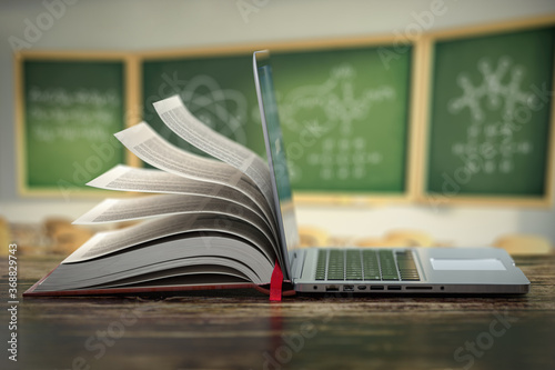 E-learning online education or internet  encyclopedia concept. Open laptop and book compilation in a classroom. photo