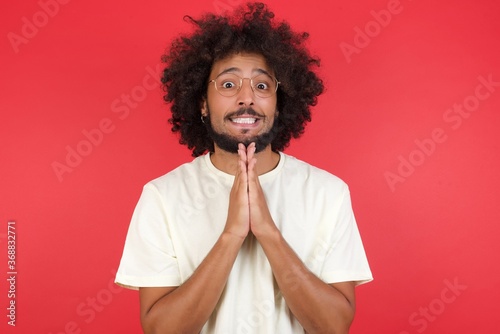 Cuadro en lienzo Horizontal portrait of pretty blond man keeps palms together, has pleased expression