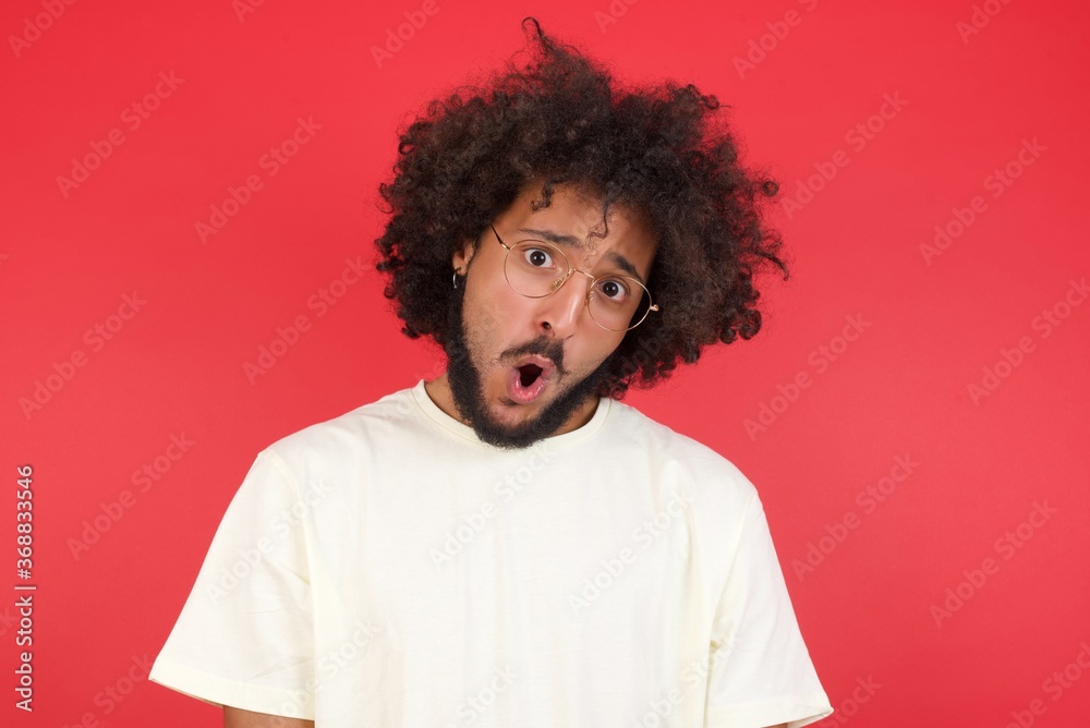 Expressive facial expressions. Shocked stupefied male, keeps jaw dropped feels stunned from what he sees aside on blank gray Wall Expressive facial expressions. Shocked stupefied male, keeps jaw dropped feels stunned from what he sees aside on blank gray Wall