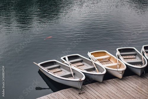 A boats tied to a wooden pier on the lake © siwarit01