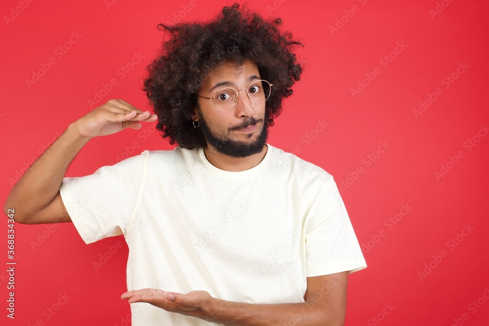 Blond European man over isolated background gesturing with hands showing big and large size sign, measure symbol. Smiling looking at the camera. Measuring concept. Blond European man over isolated background gesturing with hands showing big and large size sign, measure symbol. Smiling looking at the camera. Measuring concept.
