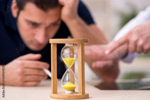 Young male patient visiting old doctor in antismoking concept