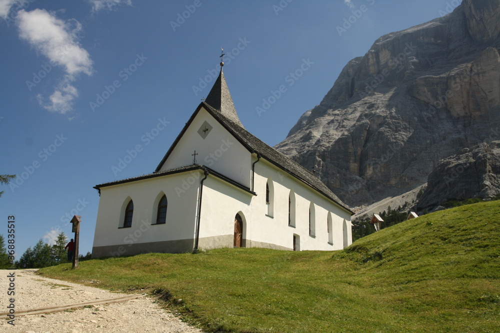 panoramic view of the meadows and mountains of the sella group in alta badia with old church. Summer La Crusc Santa Croce Sanctuary panoramic view of the meadows and mountains of the sella group in alta badia with old church. Summer La Crusc Santa Croce Sanctuary