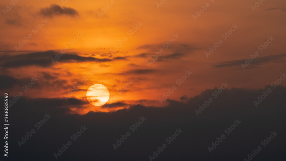 The morning sun with black clouds and orange sky, beautiful nature