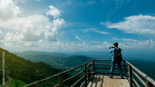 Obraz na płótnie Tourists who stand to take pictures on the bridge to see the view with beautiful mountains and skies with a rear view. w salonie