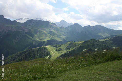 panoramic view of the meadows and fog mountains of the sella group in alta badia