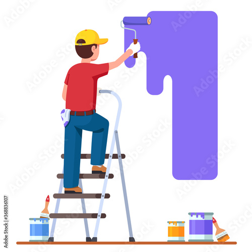 Painter man painting house wall with roller brush