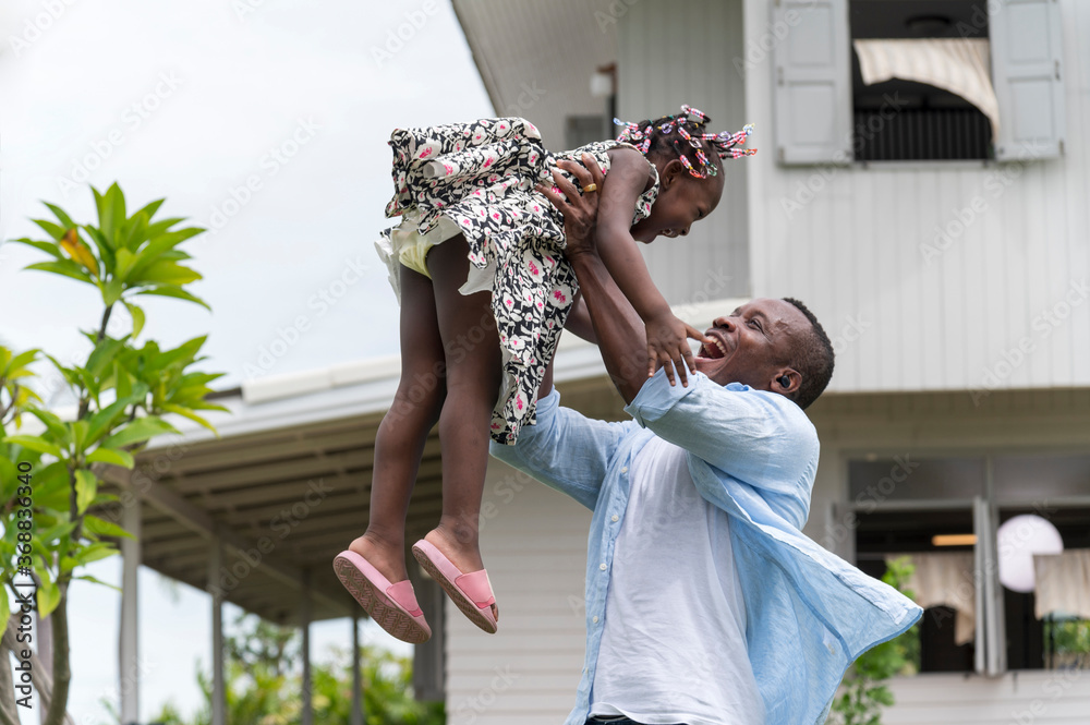Fototapeta premium Happy african american Father and Daughter child girl play throws airplane enjoying active with outside house background.