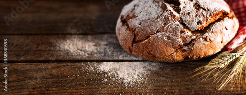 Fresh baked bread on rustic wood
Fresh crispy bread and flour on rustic wood. Horizontal background for a bakery concept with space for text. photo