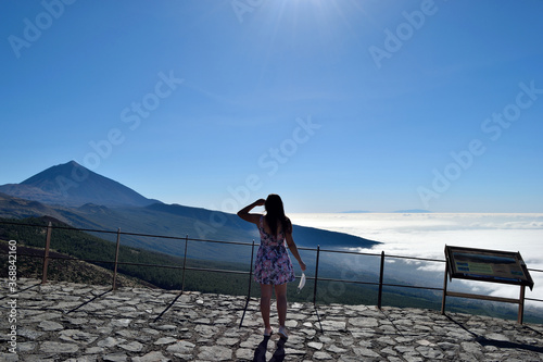 Mujer viendo el pico del Teide (Tenerife) sosteniendo una mascarilla en su mano