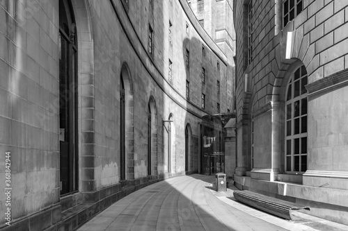 Black and white photo of the curve of library walk in Manchester with the late evening sunlight casting into the shot.  © iammattdoran