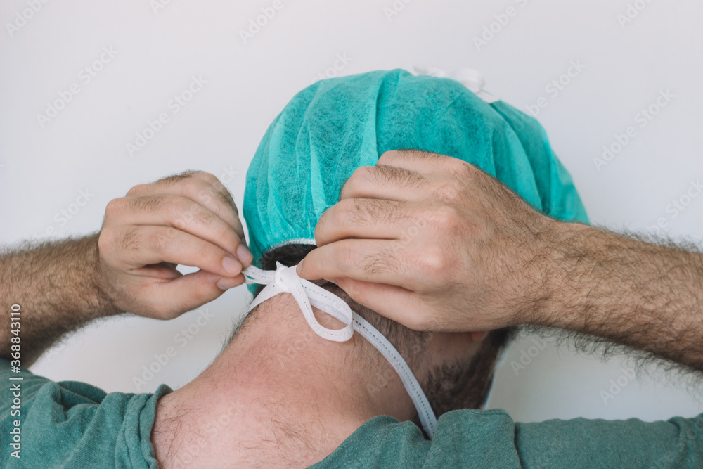 Doctor mask, corona virus protection concept isolated on white background. Man tying his mask.