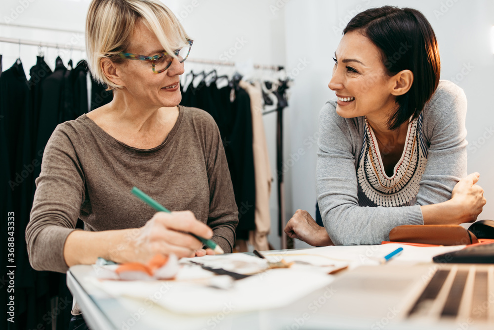 Two professional designers working in fashion studio. Creative people concept. Two professional designers working in fashion studio. Creative people concept.