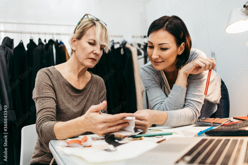 Two professional designers working in fashion studio. Creative people concept.