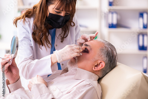 Old man visiting young female doctor for plastic surgery