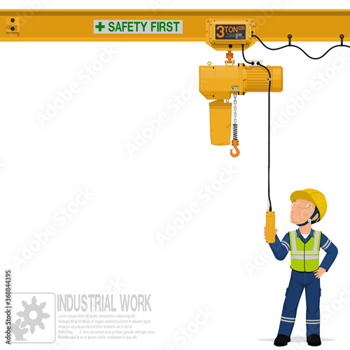 An industrial worker is operating electric chain hoist photo