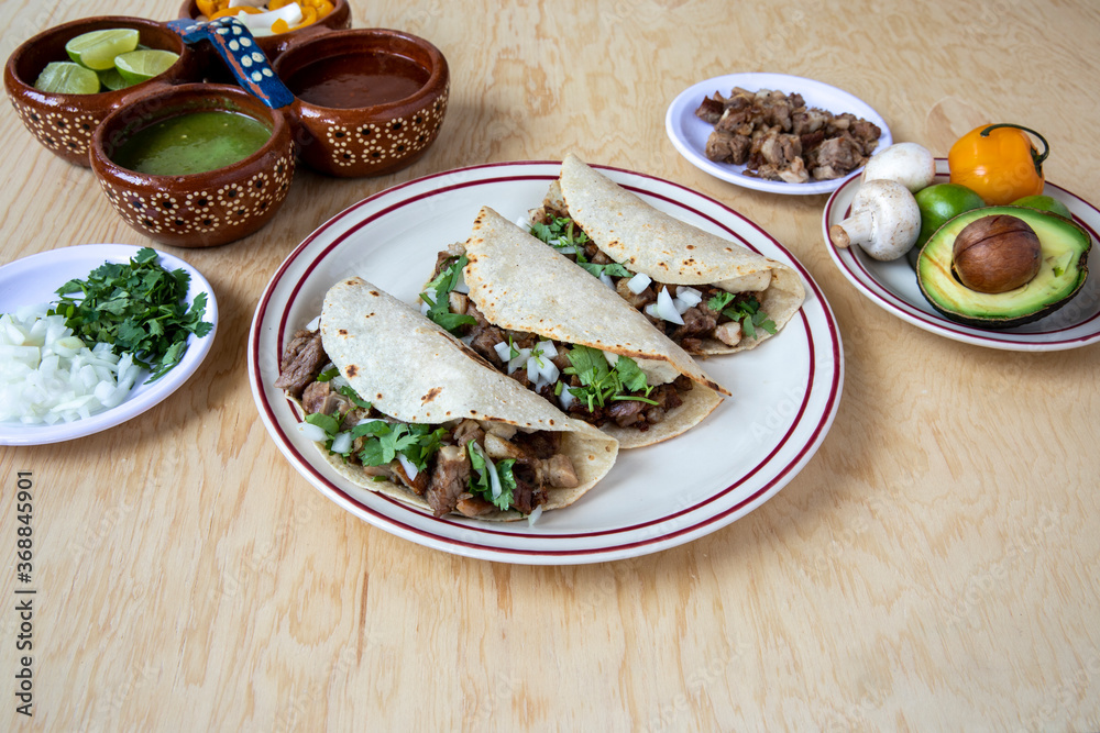 Three homemade beef tacos with other goodies at their side