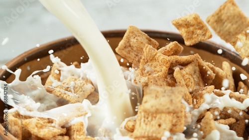 Fotografie Breakfast cereals dropping into bowl with pouring milk
