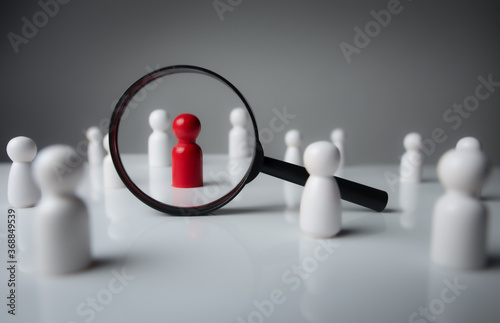 Foto a magnifying glass looking to red wood people,Select a person in the team, Human Resource