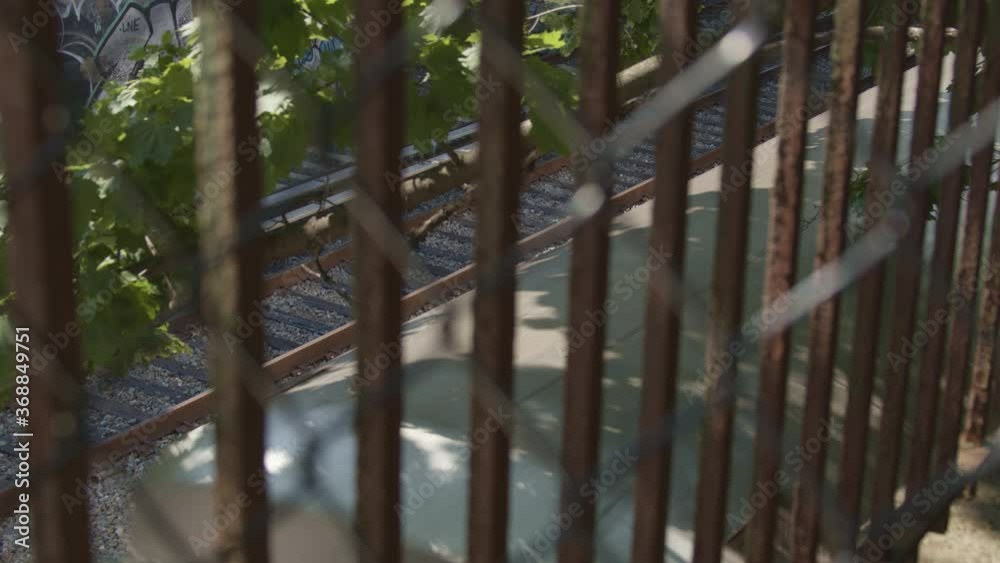 Subway Train Passes On Close Track From Above Viewed Through a Fence On An Afternoon In Brooklyn, New York Subway Train Passes On Close Track From Above Viewed Through a Fence On An Afternoon In Brooklyn, New York