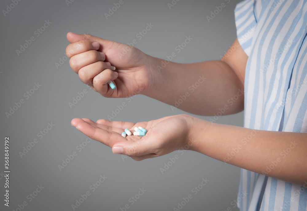 Woman holding medicine in her hands,blue and white medical capsule Woman holding medicine in her hands,blue and white medical capsule