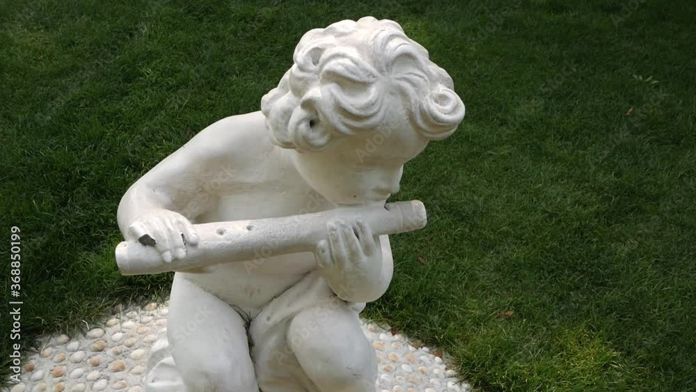 Garden figurine of a boy playing the pipe. Garden figurine of a boy playing the pipe.