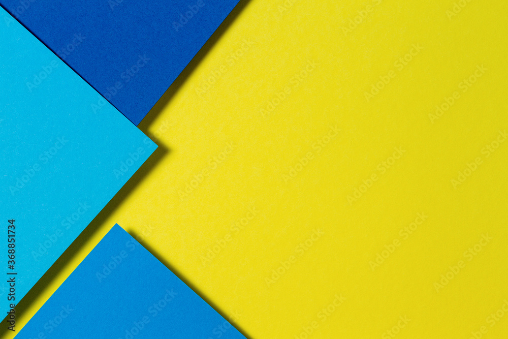 Abstract color papers geometry flat lay composition background with blue and yellow tones