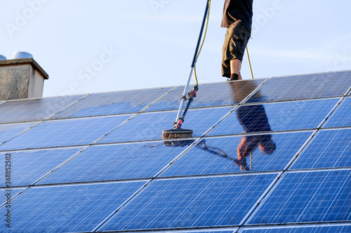 Cleaning solar panels with brush and water