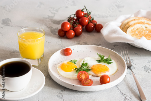 fried eggs with tomatoes and herbs, toast, coffee and juice