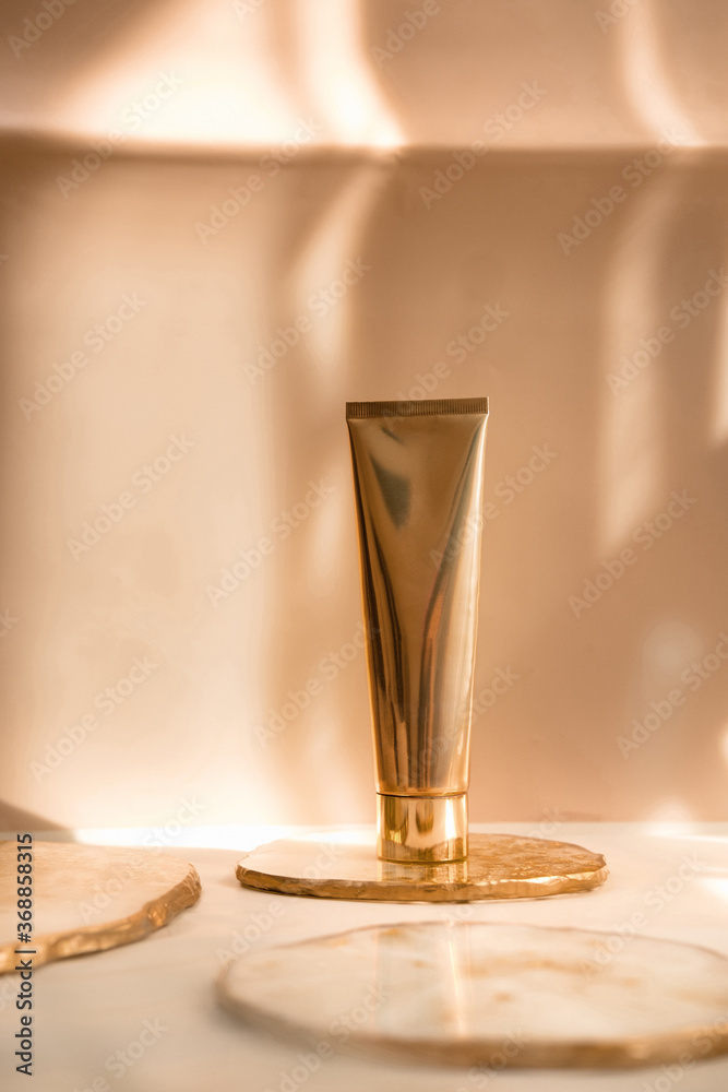 Golden cosmetic tube light pastel color background, lights and shadows. Natural minimalism look, clean sustainable concept. Minimal styling, still life. Beauty blogging, branding layout, skin care ad Golden cosmetic tube light pastel color background, lights and shadows. Natural minimalism look, clean sustainable concept. Minimal styling, still life. Beauty blogging, branding layout, skin care ad