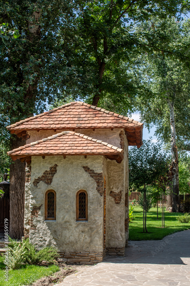 Old Mediterranean stone house in green garden. Mediterranean style decoration of a garden  
