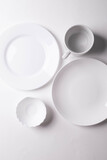 a group of different white ceramic plates on white background