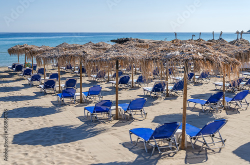 Straw beach umbrellas and sun chairs on the east coast of Zakynthos island in Greece © Darios